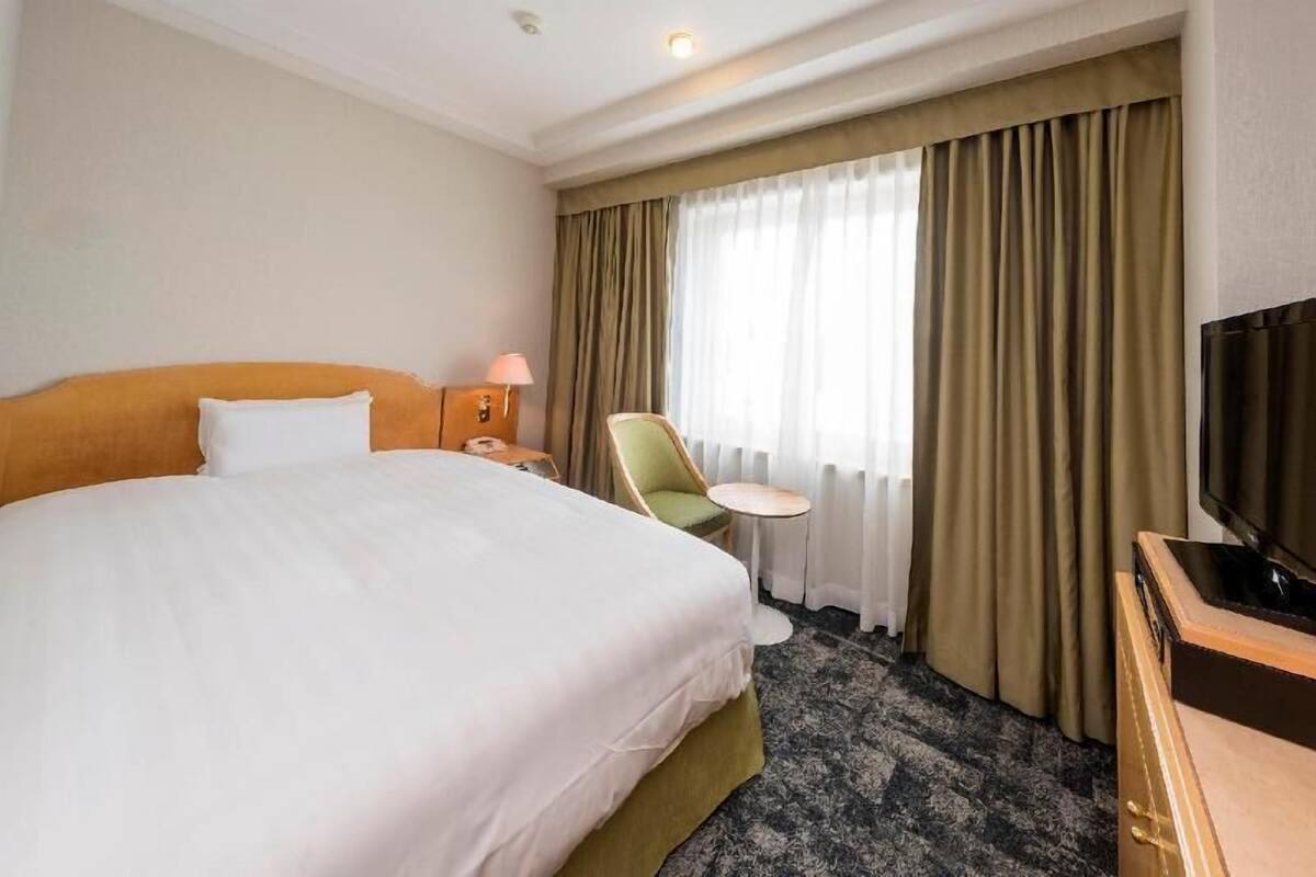 Ylelliset vuodevaatteet, untuvapeitot, tallelokero huoneessa, työpöytä