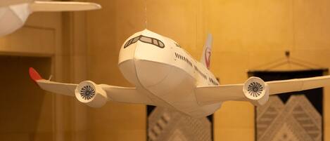 Un modèle d’avion suspendu dans une pièce dont les murs sont décorés de motifs.