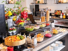A buffet with various food items and a coffee station.