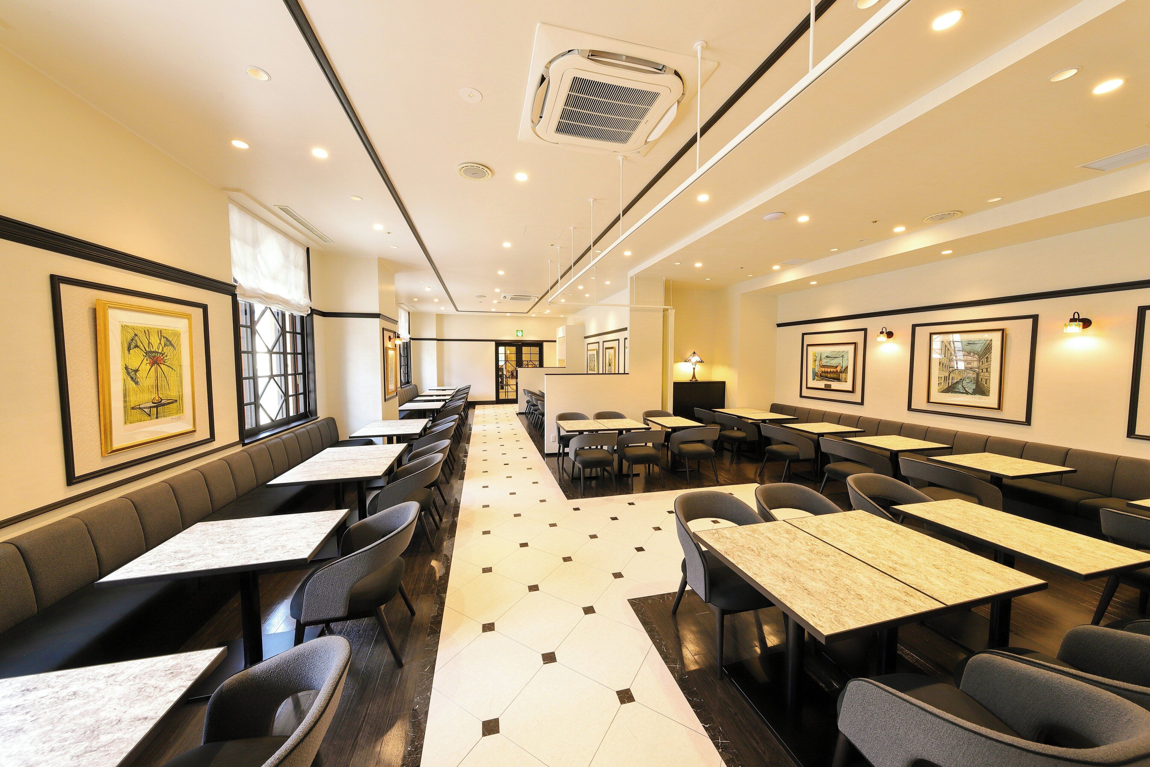 A restaurant with booths and tables, a tiled floor, and framed artwork on the walls.