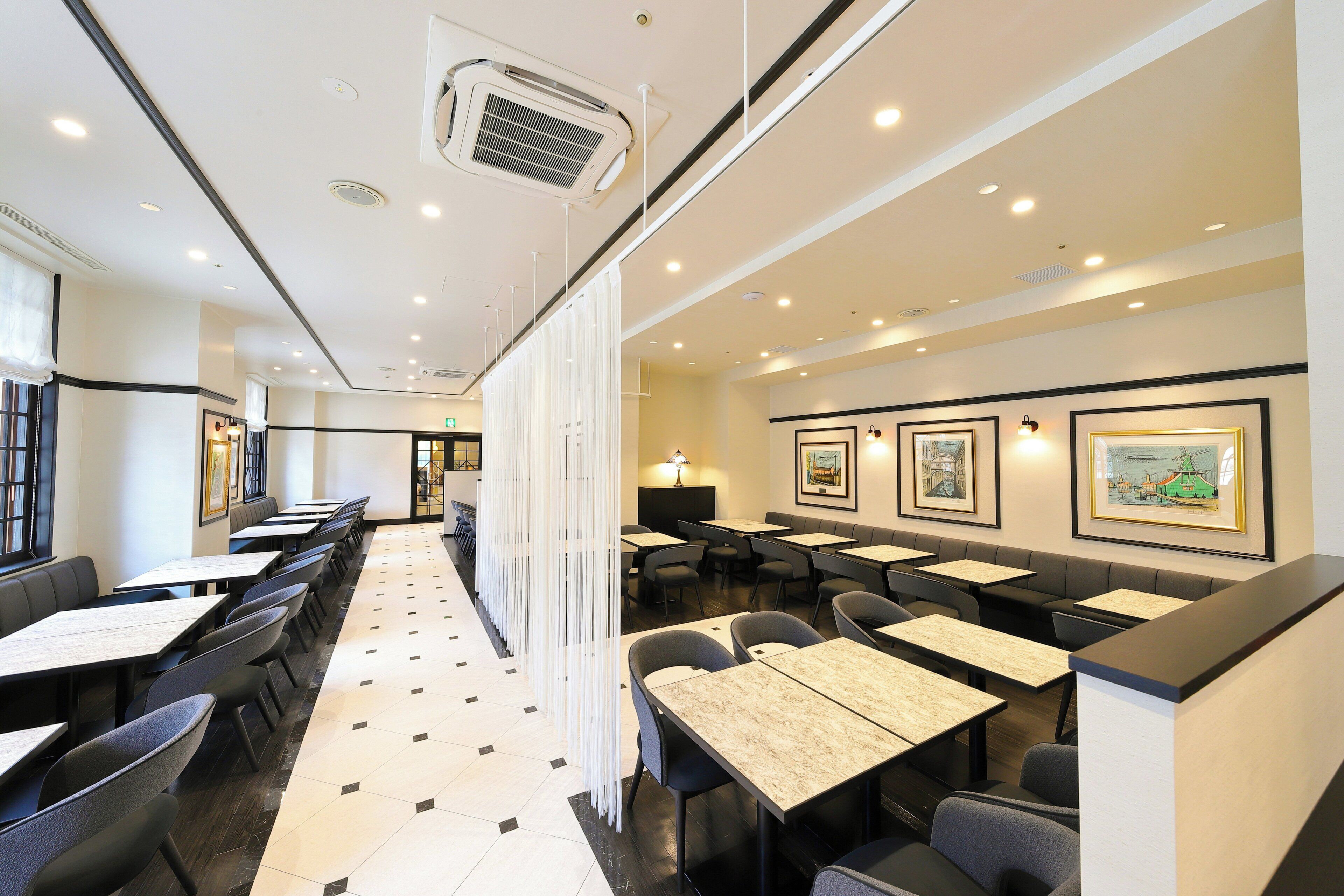 A restaurant with booths and tables, a tiled floor, and framed pictures on the walls.