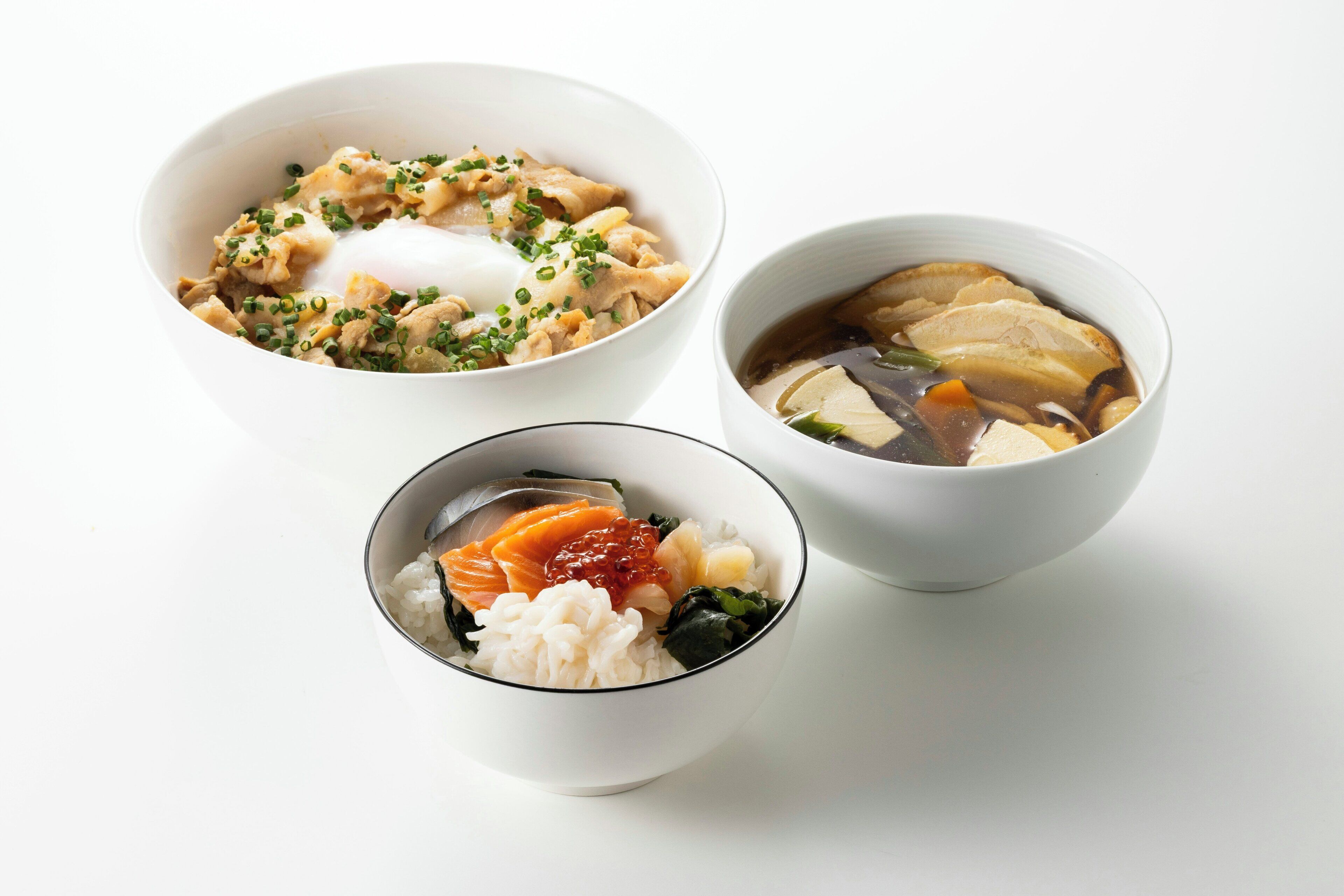 Three bowls of food with different ingredients and garnishes.
