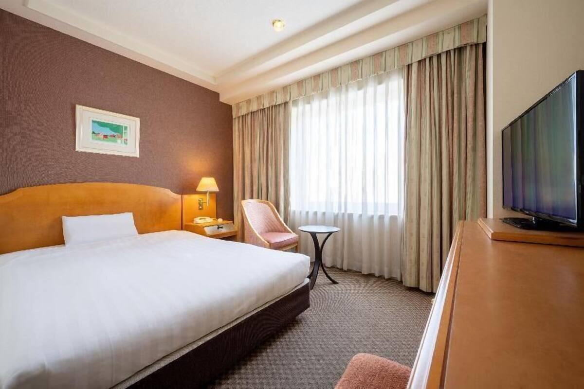 Ylelliset vuodevaatteet, untuvapeitot, tallelokero huoneessa, työpöytä