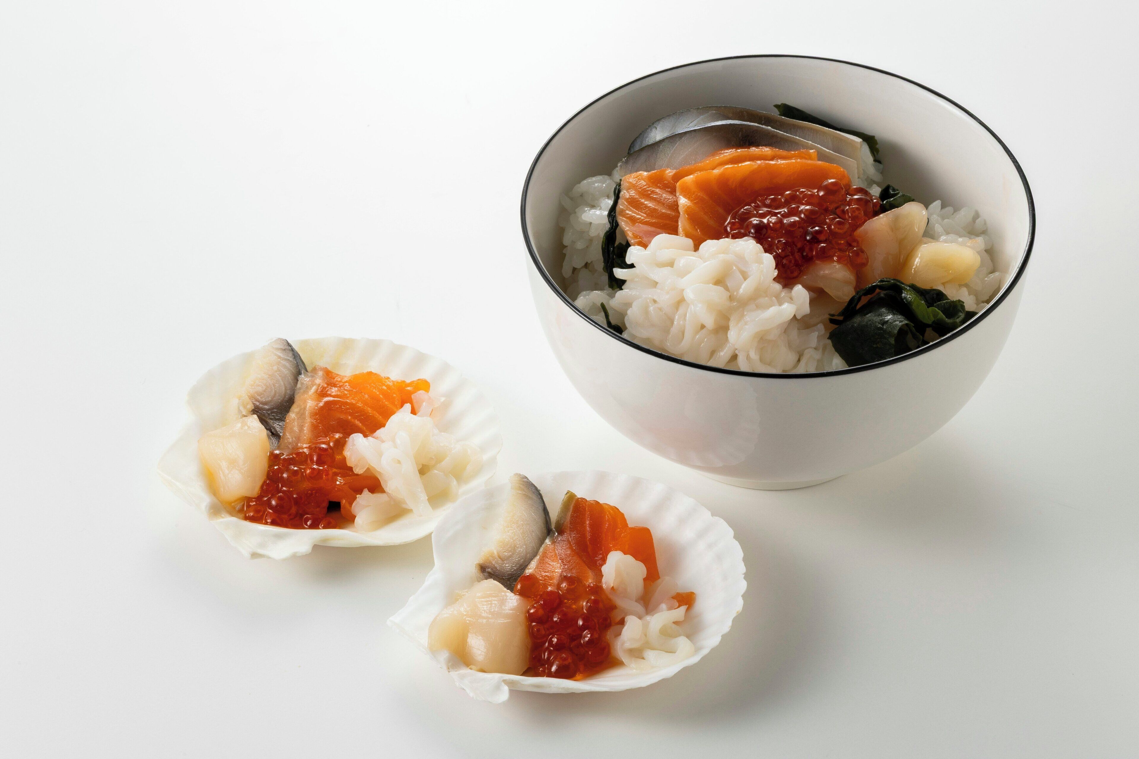 Eine Schüssel Sushi mit Reis, Fisch und Fischrogen.