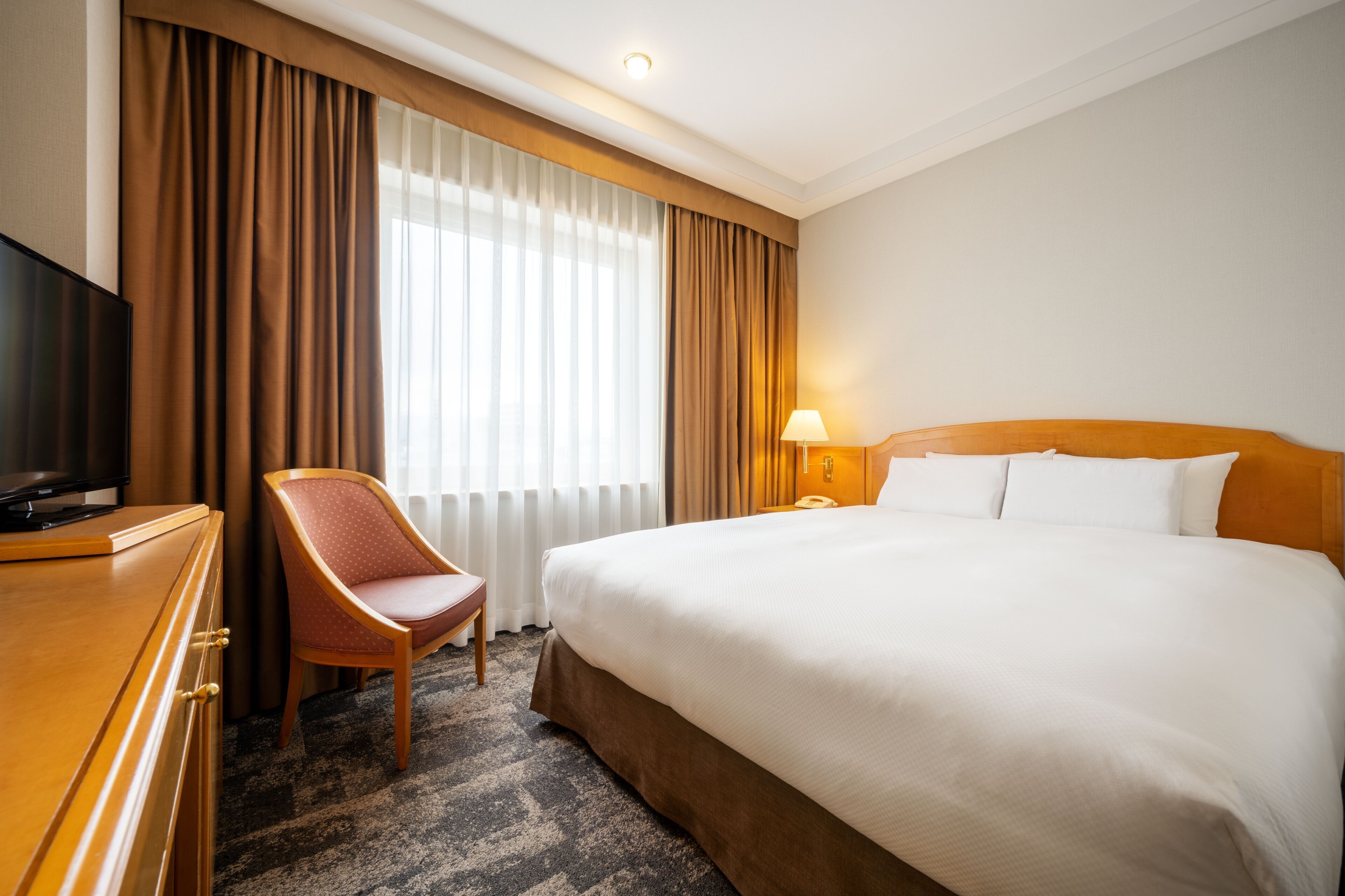 Ylelliset vuodevaatteet, untuvapeitot, tallelokero huoneessa, työpöytä