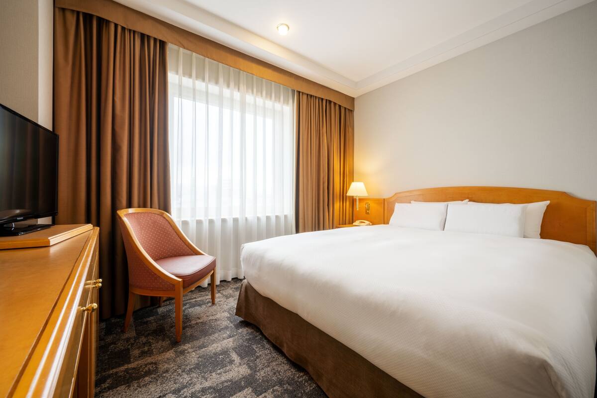 Ylelliset vuodevaatteet, untuvapeitot, tallelokero huoneessa, työpöytä