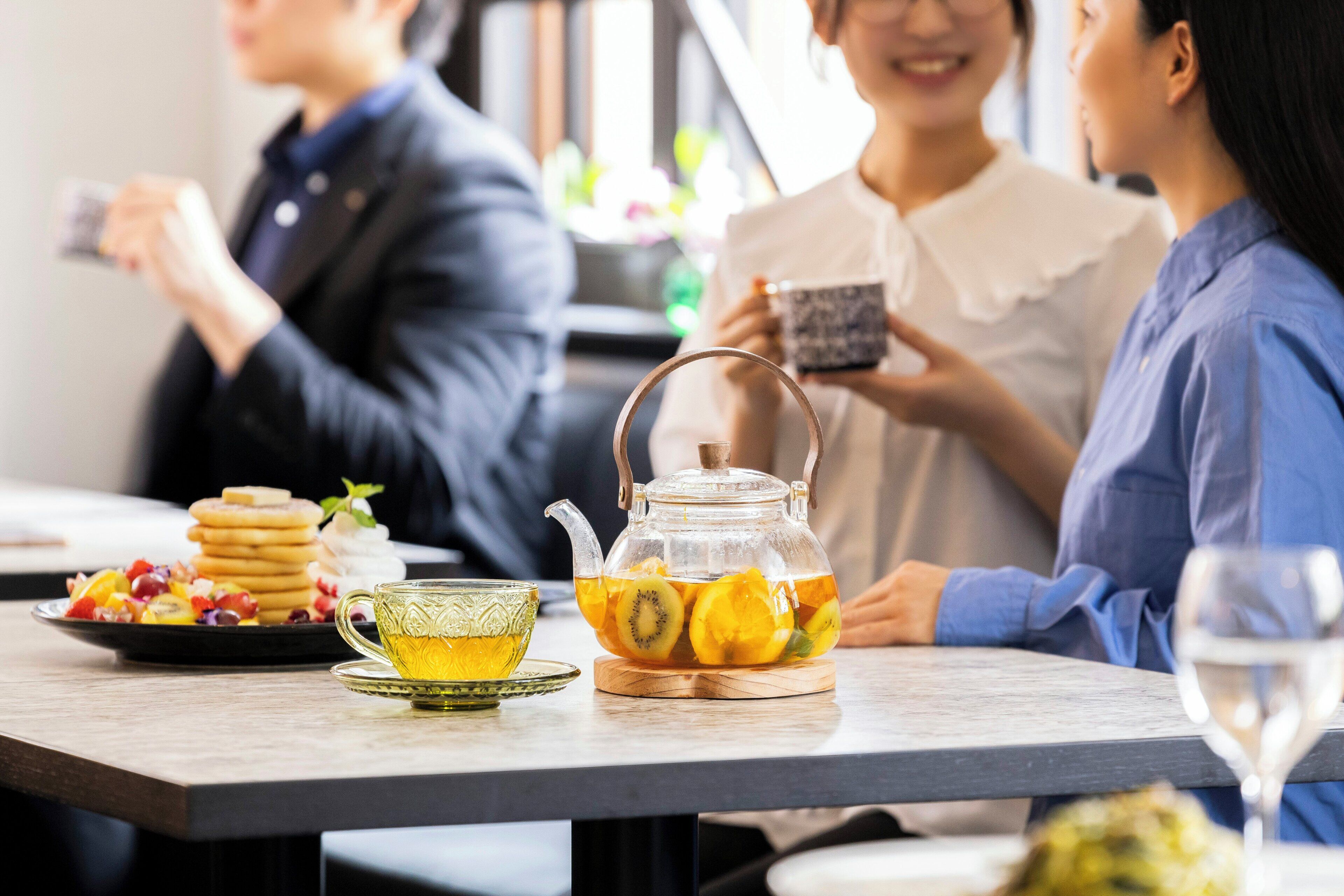 A table with a teapot, a cup, and a glass of water, suggesting a dining or tea setting.