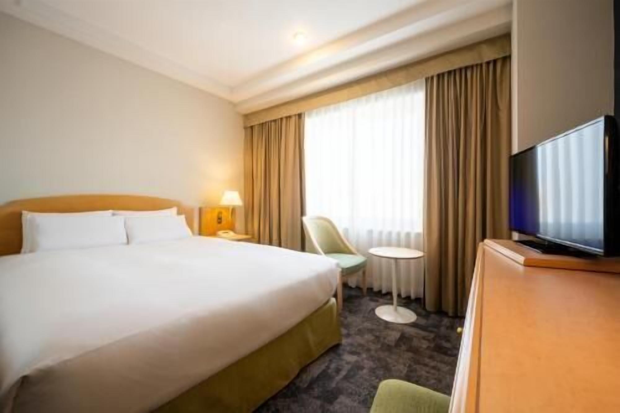 Ylelliset vuodevaatteet, untuvapeitot, tallelokero huoneessa, työpöytä