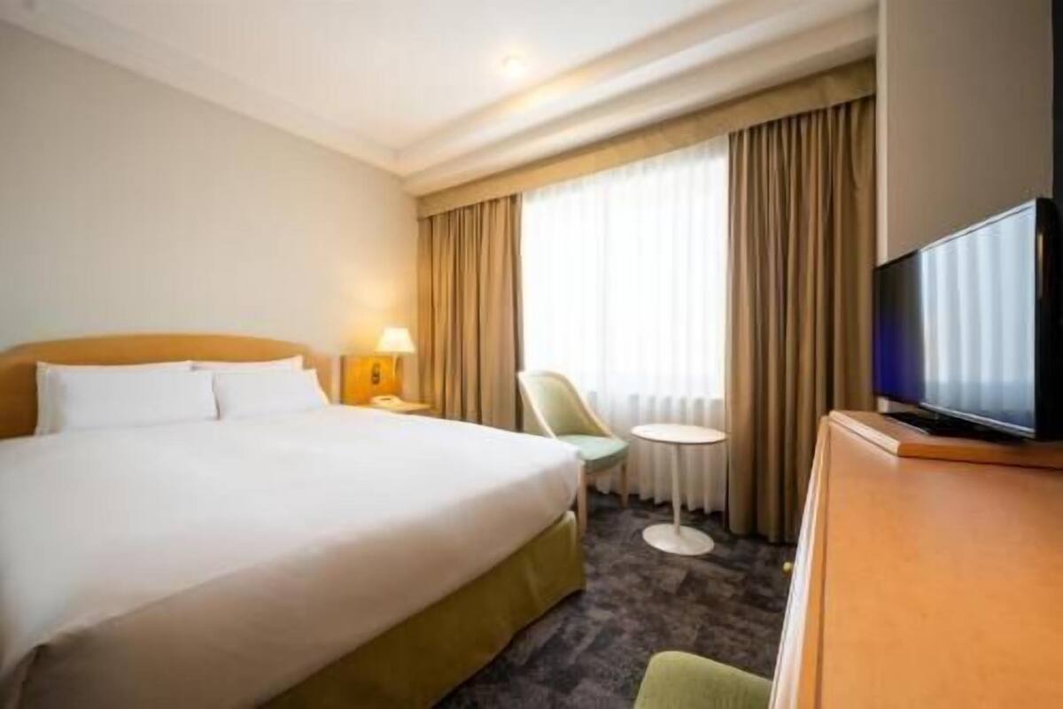 Ylelliset vuodevaatteet, untuvapeitot, tallelokero huoneessa, työpöytä