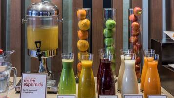 A juice bar with various fruit juices and a large punch dispenser.