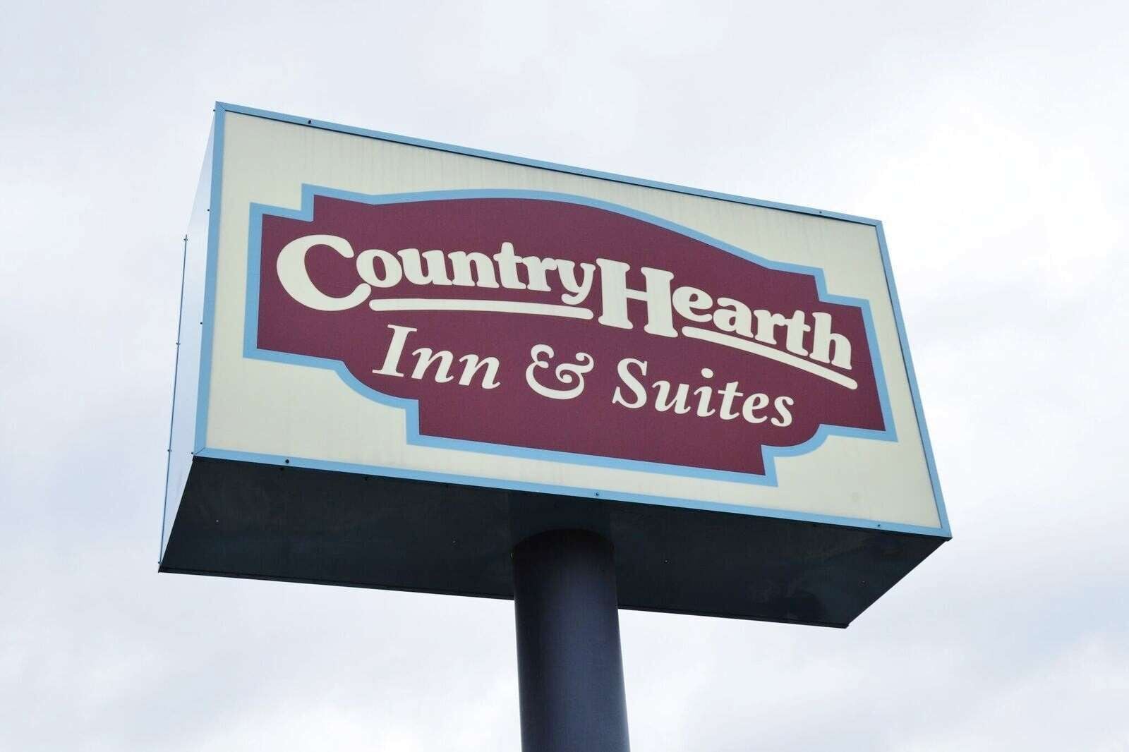 A sign for Country Hearth Inn & Suites.