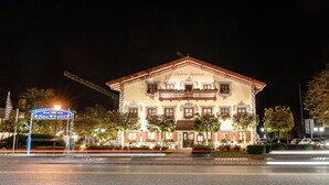 A historic building with a balcony, a signboard, and a well-lit entrance. - Hotel Sauerlacher Post (Sauerlach)