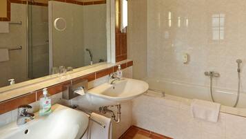 A bathroom with two sinks, a mirror, a shower, and a towel rack.