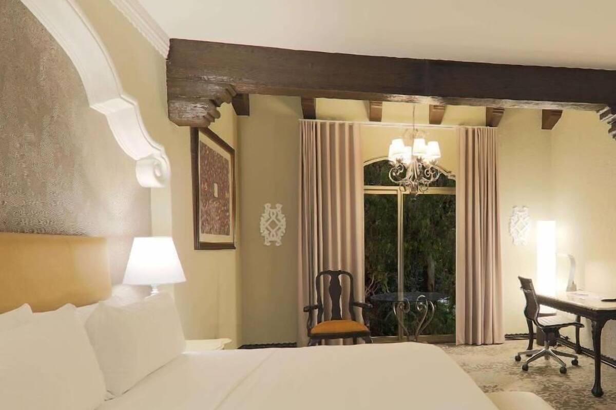 Een hotelkamer met een groot bed, een bureau en een stoel.