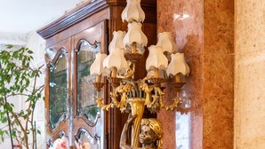 A room with a yellow sofa, a wooden cabinet, and a decorative wall piece. - Hôtel Minerve Paris (Paris)