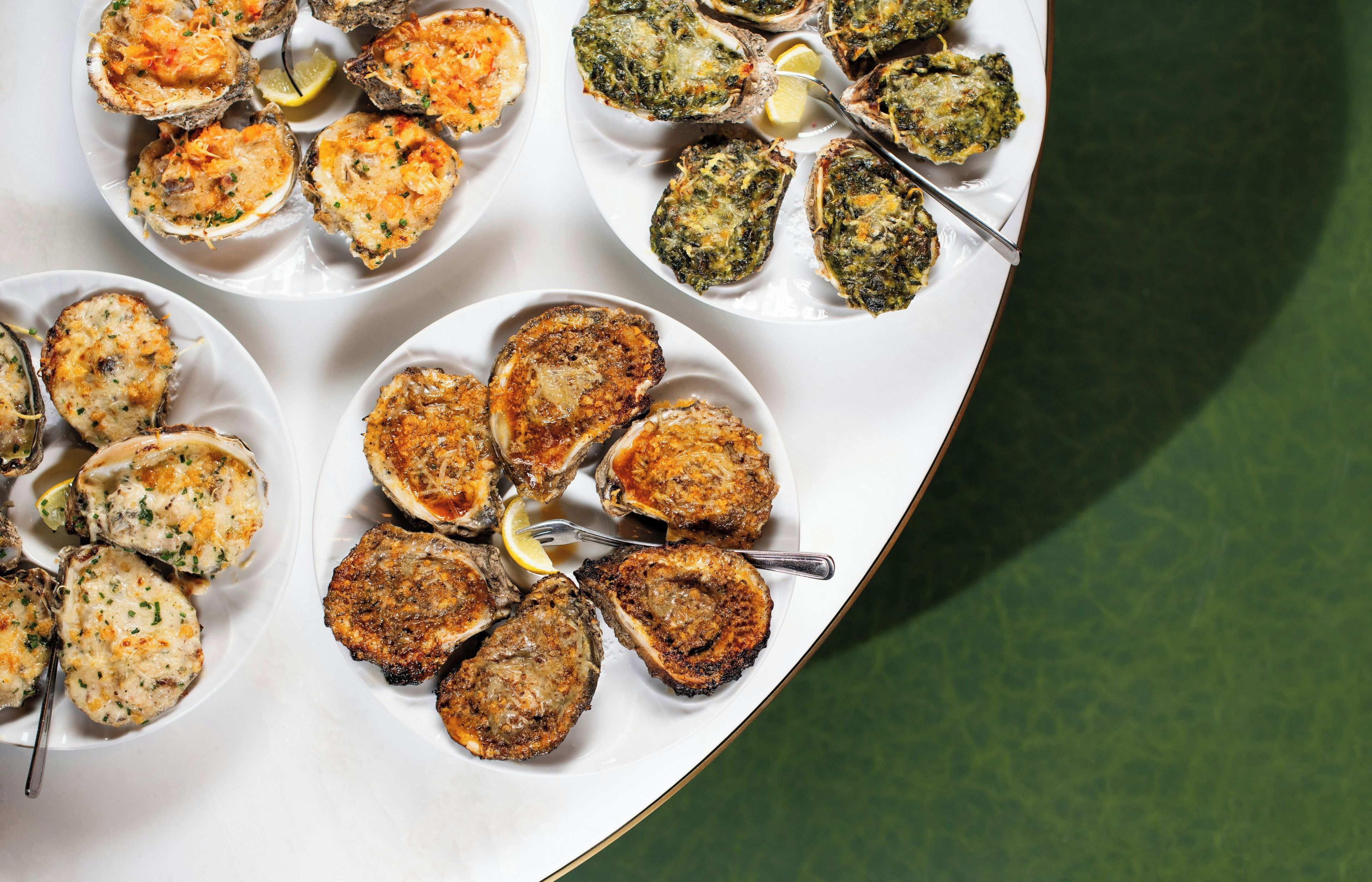 Variedad de platos de mariscos, incluyendo ostras y pasteles de centolla.