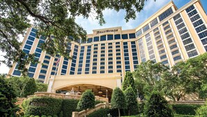 A large hotel with a prominent entrance, multiple floors, and a well-maintained garden with hedges and flowers. - Beau Rivage (Biloxi)