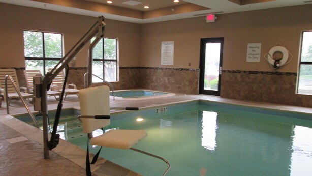 Une piscine intérieure avec un poste de surveillance pour sauveteur, un jacuzzi et un panneau indiquant qu’il n’y a pas de sauveteur en service.