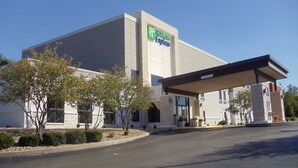 Un bâtiment de l’hôtel Holiday Inn Express doté d’une entrée couverte et surplombant un ciel dégagé.
