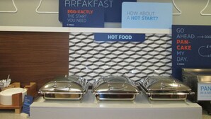 Un présentoir de produits pour le petit-déjeuner, avec divers aliments et des panneaux publicitaires.
