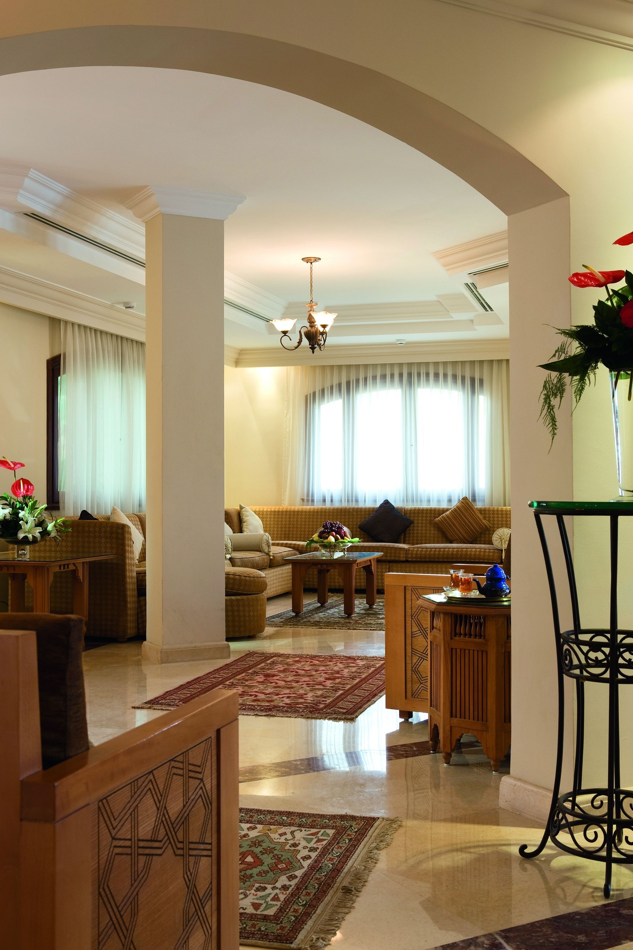 A spacious living room with a sofa set, a coffee table, and a decorative vase.