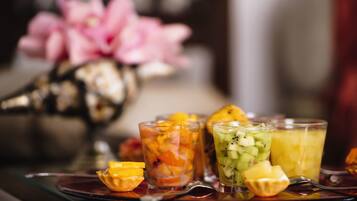 A tray with three fruit-infused drinks and a spoon.