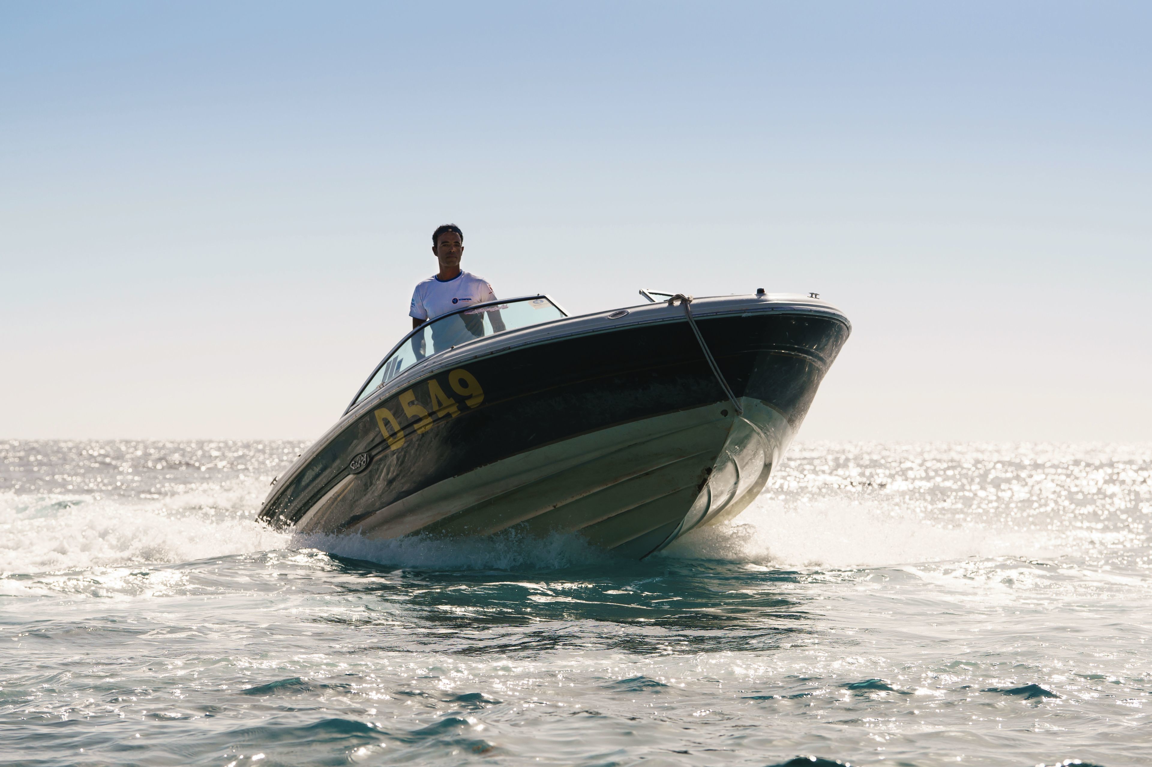 A speedboat with the number 0549 on its side moving through the water.