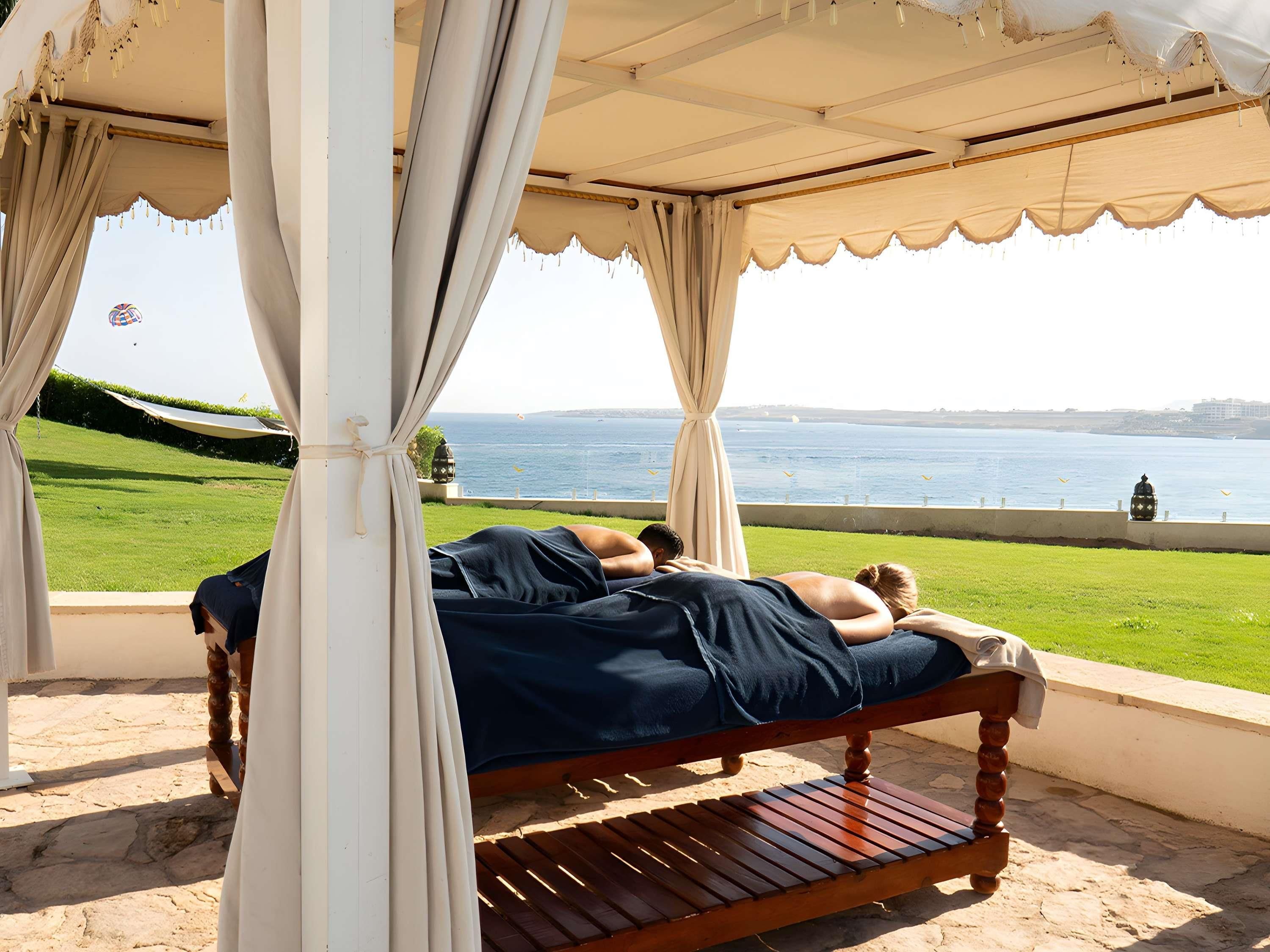 Un lit sous un dais avec vue sur la mer.