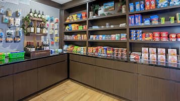 A store interior with shelves stocked with snacks, beverages, and packaged goods.