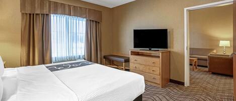 Une chambre d’hôtel avec un grand lit, une télévision, un bureau et une chaise.