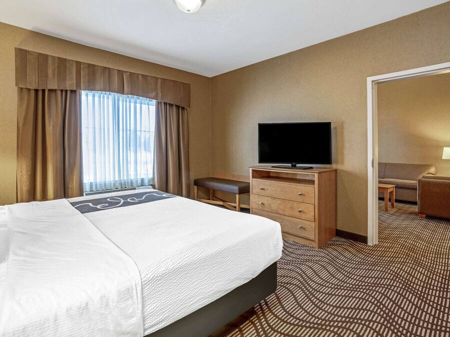 Une chambre d’hôtel avec un grand lit, une télévision, un bureau et une chaise.