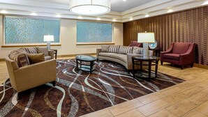 A modern living room with a sofa, armchairs, a coffee table, and a patterned rug. - La Quinta Inn & Suites by Wyndham Coeur d`Alene (Coeur d'Alene)