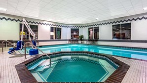 A large indoor swimming pool with a zigzag tile border, a ladder, and blue chairs. - La Quinta Inn & Suites by Wyndham Coeur d`Alene (Coeur d'Alene)