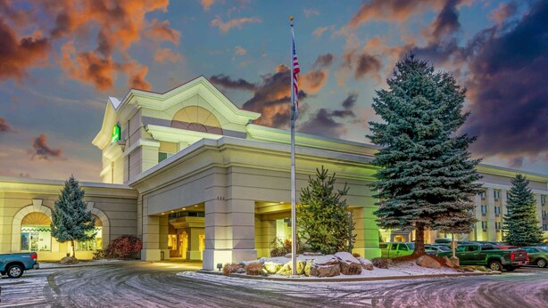 A hotel with a prominent American flag, a well-lit entrance, and snow-covered surroundings. - La Quinta Inn & Suites by Wyndham Coeur d`Alene (Coeur d'Alene)