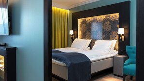 A hotel room with a bed, bedside lamps, a TV, a chair, and a nightstand. - Thon Hotel Terminus (Oslo)