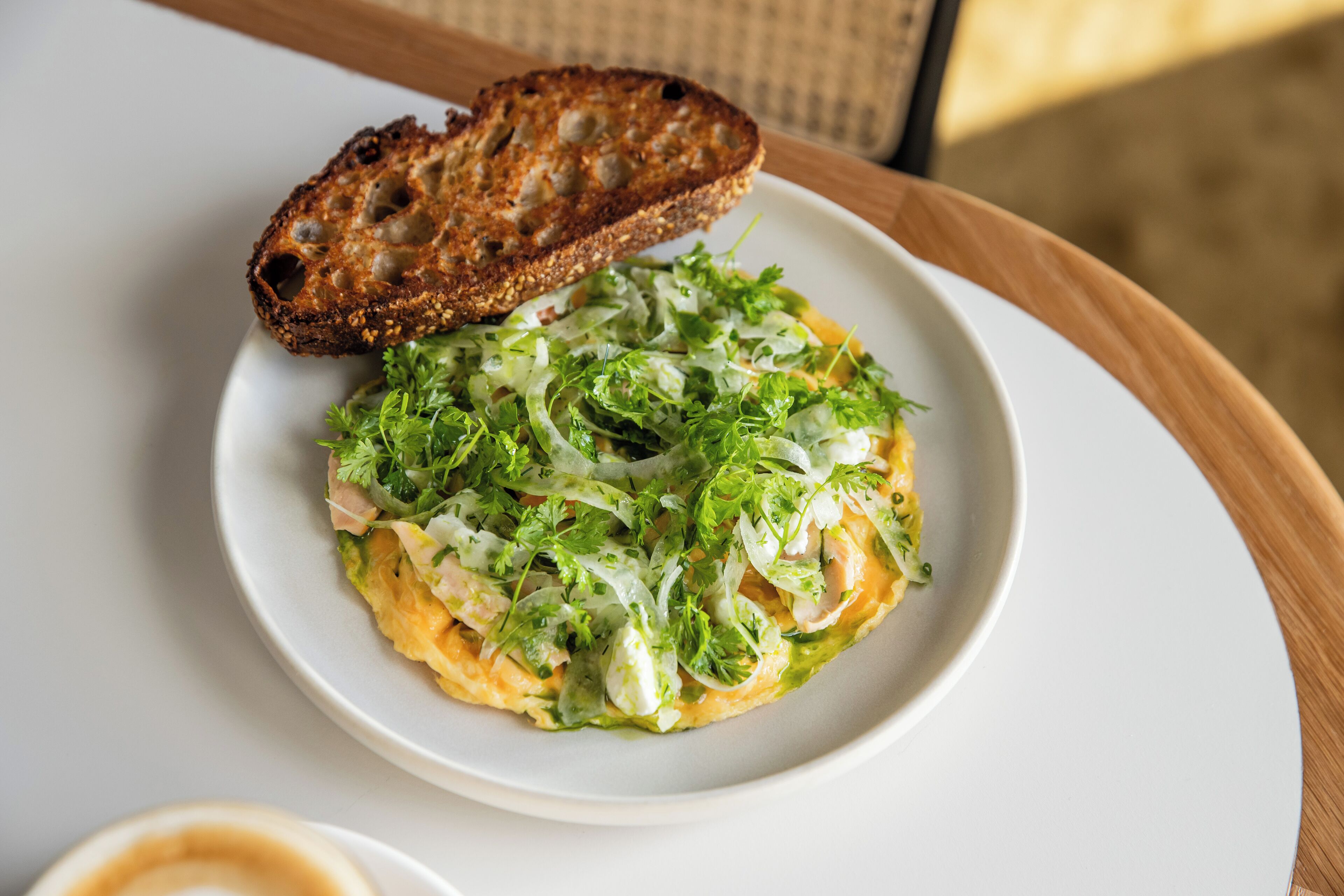 A plate of food with a slice of toasted bread on a white plate.