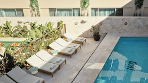 Uma área à beira da piscina com espreguiçadeiras e piscina.