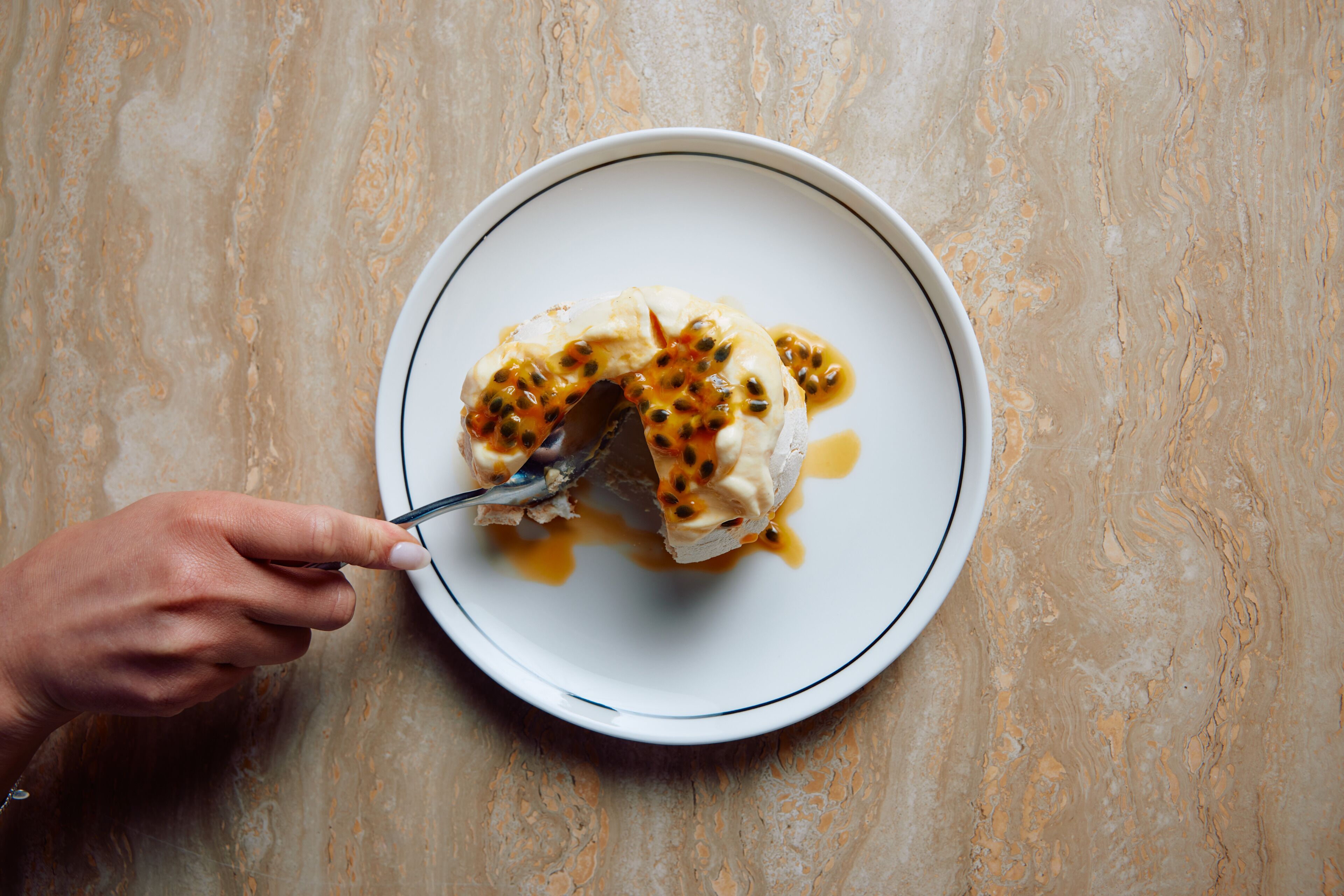 A plate with a dessert on a marble surface.