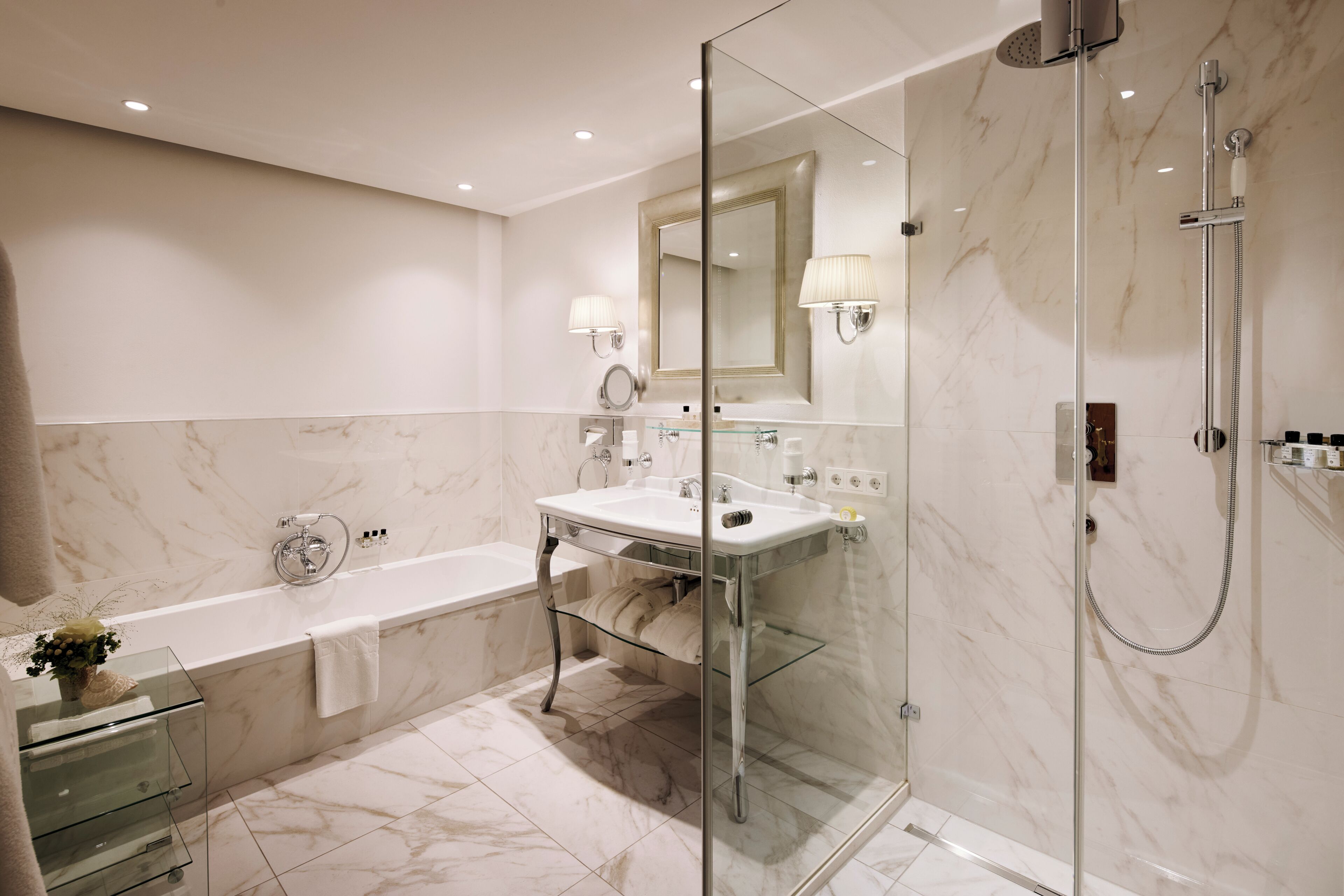 Une salle de bain moderne dotée d’une douche à parois de verre, d’une baignoire sur pieds et d’un meuble-lavabo avec miroir.