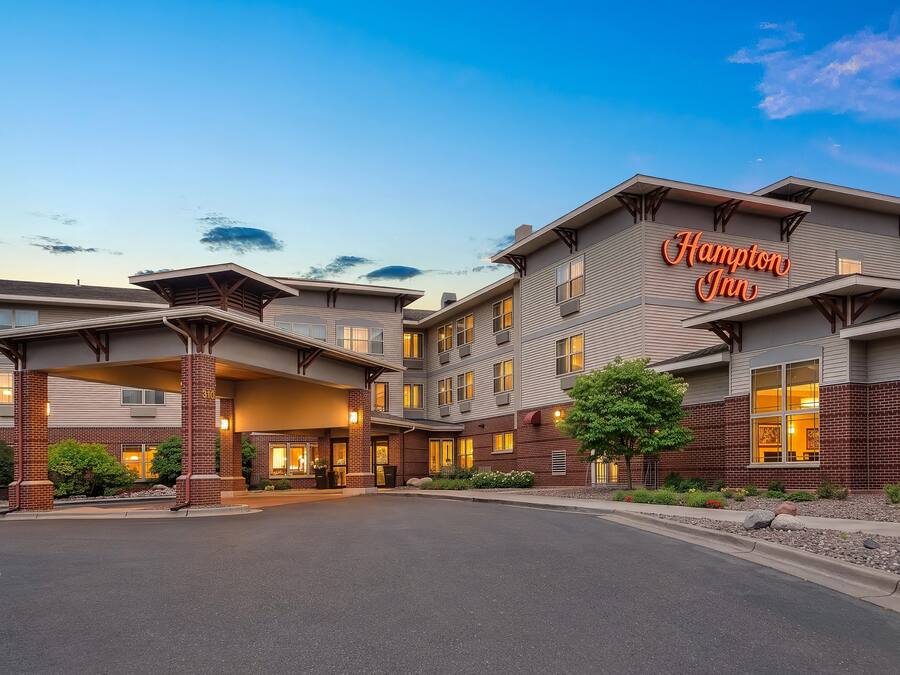 A Hampton Inn hotel with a modern architectural design, featuring a prominent entrance and multiple windows.