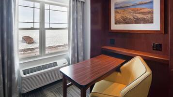 Escritorio, cortinas blackout y tabla de planchar con plancha