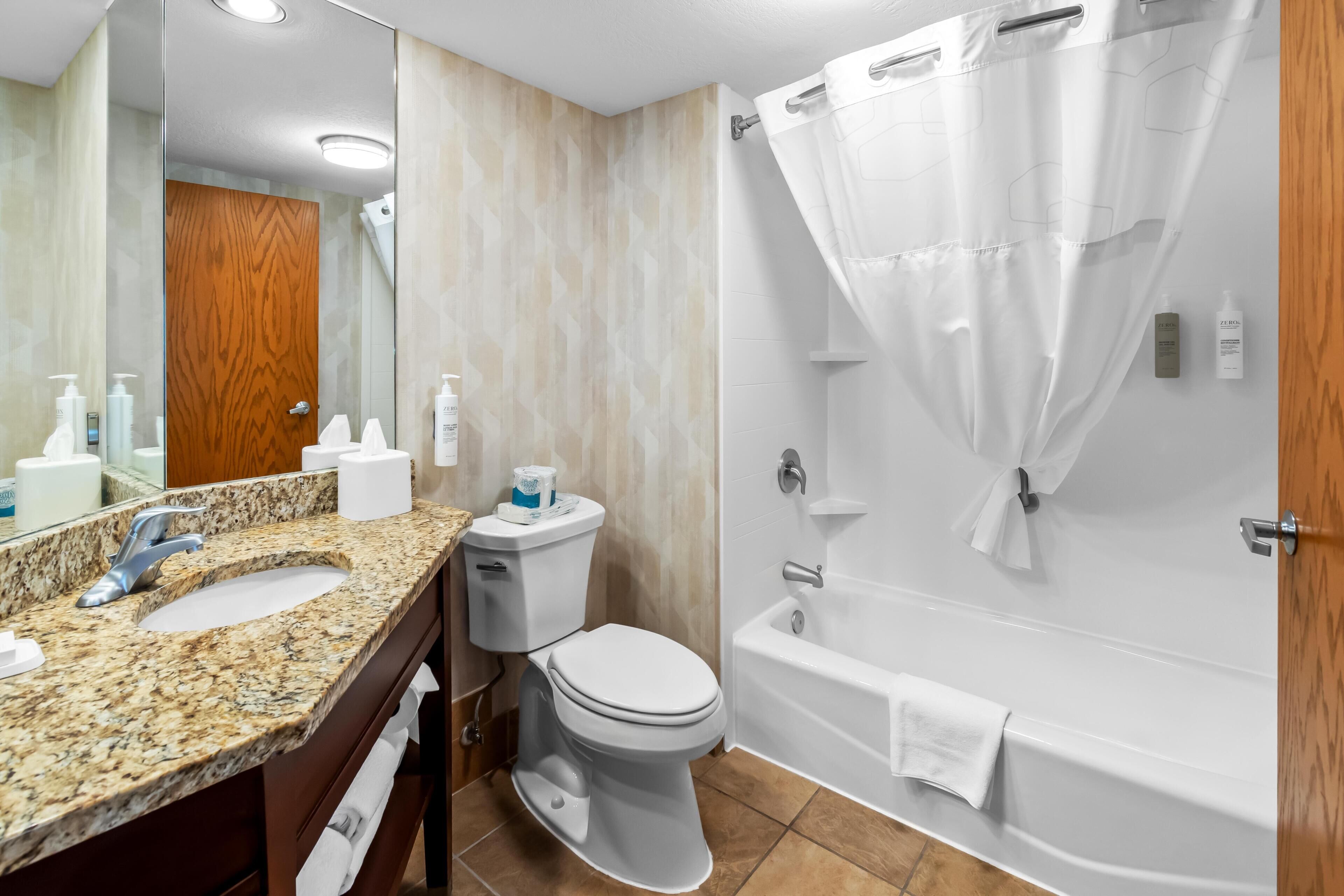 A bathroom with a sink, toilet, and bathtub.