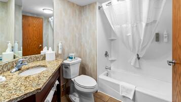 A bathroom with a sink, toilet, and bathtub.