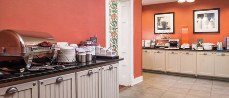 A kitchen with a built-in grill, a coffee station, and a breakfast bar.