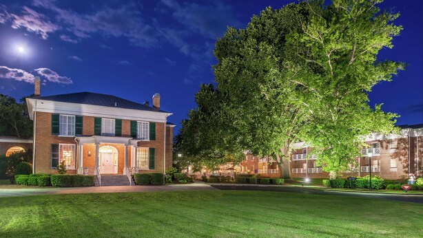 A brick building with a large tree in front, well-lit at night. - Hampton Inn Lexington-Historic District (Lexington)