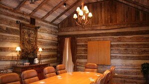 A log cabin-style room with a large wooden dining table, leather chairs, a chandelier, and a fireplace. - Hampton Inn Lexington-Historic District (Lexington)