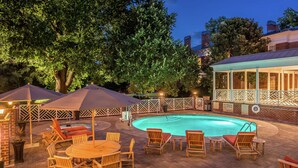 A backyard with a swimming pool, wooden chairs, and umbrellas. - Hampton Inn Lexington-Historic District (Lexington)