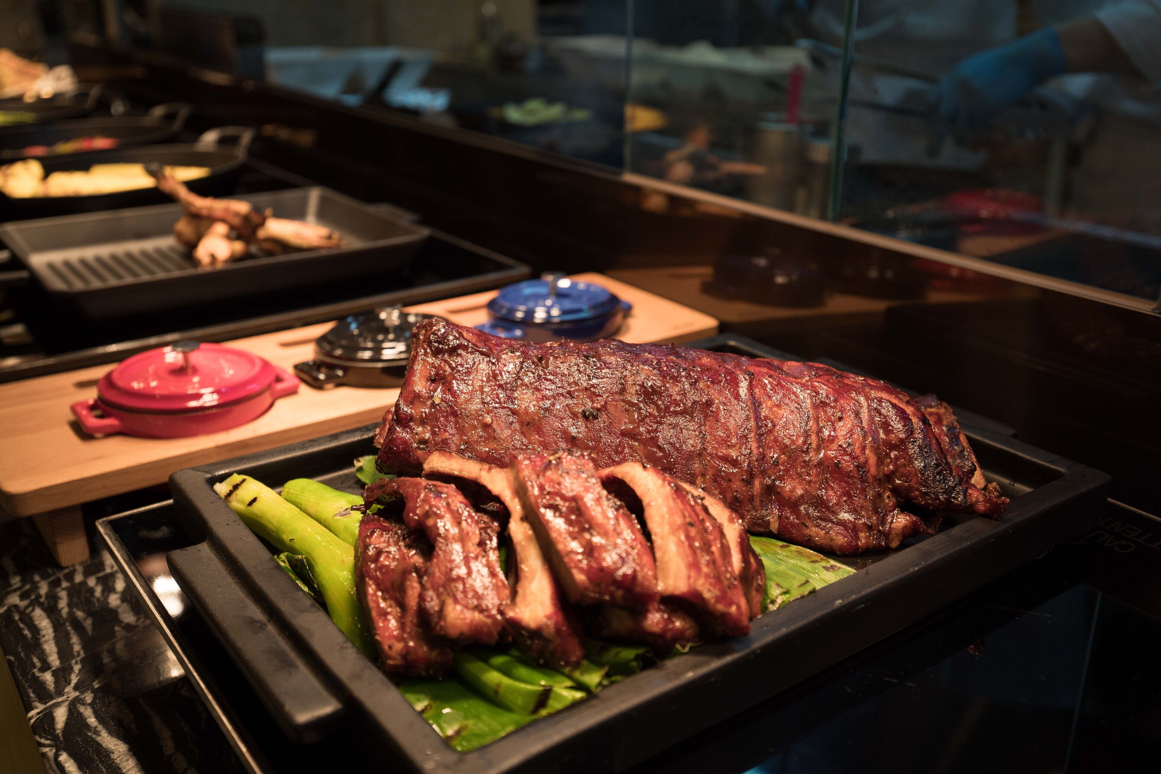 Un plato de carne asada con verduras en una bandeja.