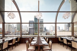 Enjoy a panoramic view of the city skyline from this spacious dining area with a curved glass wall.