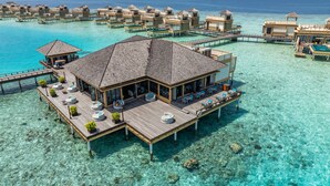 Wasserbungalows mit mehreren Ebenen, verbunden durch Gehwege, mit Außenbereich zum Sitzen.